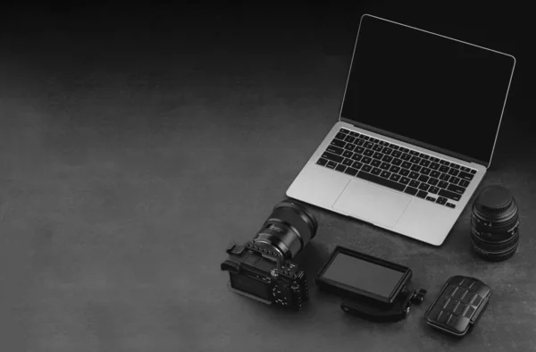 暗い背景にワークスペースのモックアップテンプレート カメラ ノートパソコン 再生モニター メモリカードホルダーとレンズとビデオカメラの職場 — ストック写真