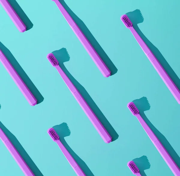 Toothbrushes pattern on a blue background. The concept of daily oral care. Advertising poster concept.