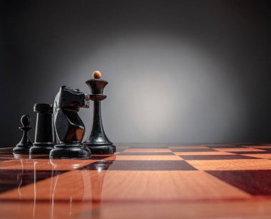 Satranç masası oyun konsepti iş fikirleri ve strateji fikirleri konsepti. Koyu gri arka planda tahta üzerinde satranç figürleri 