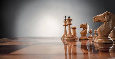 Satranç masası oyun konsepti iş fikirleri ve strateji fikirleri konsepti. Koyu gri arka planda tahta üzerinde satranç figürleri 