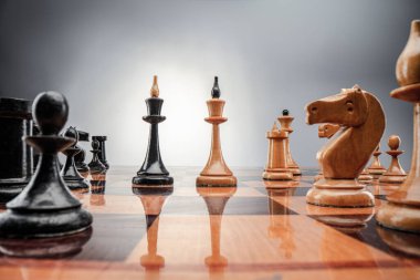 Satranç masası oyun konsepti iş fikirleri ve strateji fikirleri konsepti. Koyu gri arka planda tahta üzerinde satranç figürleri 