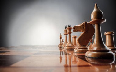 Satranç masası oyun konsepti iş fikirleri ve strateji fikirleri konsepti. Koyu gri arka planda tahta üzerinde satranç figürleri 