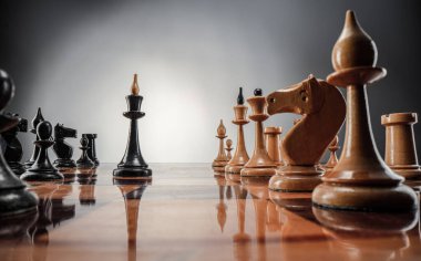 Satranç masası oyun konsepti iş fikirleri ve strateji fikirleri konsepti. Koyu gri arka planda tahta üzerinde satranç figürleri 