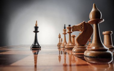 Satranç masası oyun konsepti iş fikirleri ve strateji fikirleri konsepti. Koyu gri arka planda tahta üzerinde satranç figürleri 