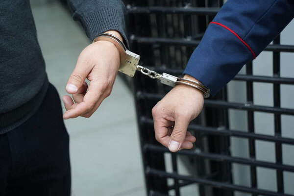 Офицер полиции надел наручники на подозреваемого