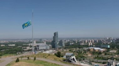 Almaty, Kazakistan - 07.13.2020: Kentsel binaların arka planında Kazakistan Cumhuriyeti 'nin ulusal bayrağı.