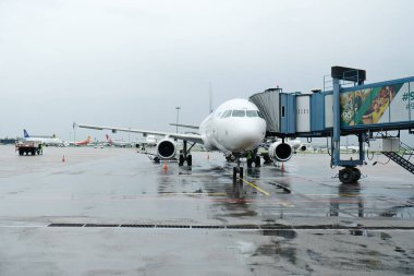 Almaty, Kazakistan - 05.02.2019: Astana Hava Yolları uçağı yolculara binmeye ve yağmurlu havalarda havalimanından kalkmaya hazırlanıyor.