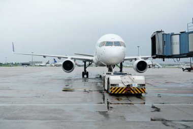 Almaty, Kazakistan - 05.02.2019: Astana Hava Yolları uçağı yolculara binmeye ve yağmurlu havalarda havalimanından kalkmaya hazırlanıyor.