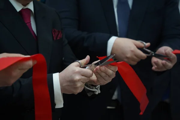 Menschen Businessanzügen Durchschneiden Das Rote Band Bei Der Eröffnung — Stockfoto