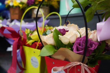 Satılık dekoratif kağıtlı parlak buketler.