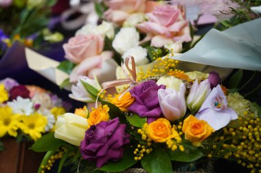 Satılık dekoratif kağıtlı parlak buketler.