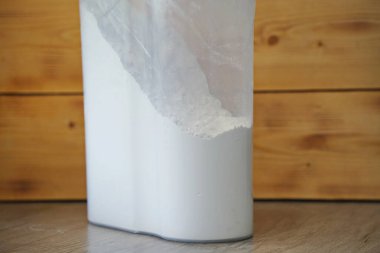 Masanın üzerinde ellenmiş un olan bir kap var.