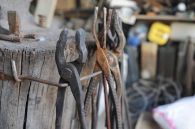Almaty, Kazakhstan - 09.24.2015 : Various blacksmith's tools on a wooden stand in the workshop