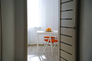 Corridor with a door and a view of the kitchen table