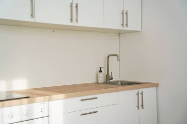 Kitchen sink and hanging cabinets for plates and utensils.