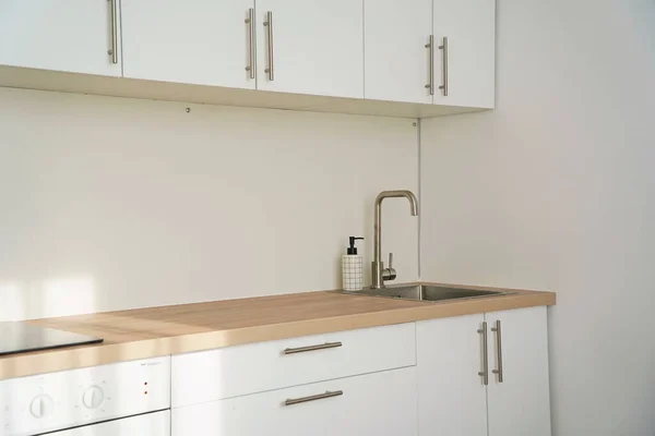 Kitchen sink and hanging cabinets for plates and utensils.