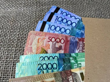 Kazak banknotları ve kağıt bir zarf masanın üzerinde..