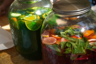 Taze meyve ve meyvelerden yapılmış meşrubatlı büyük cam kavanozlar..