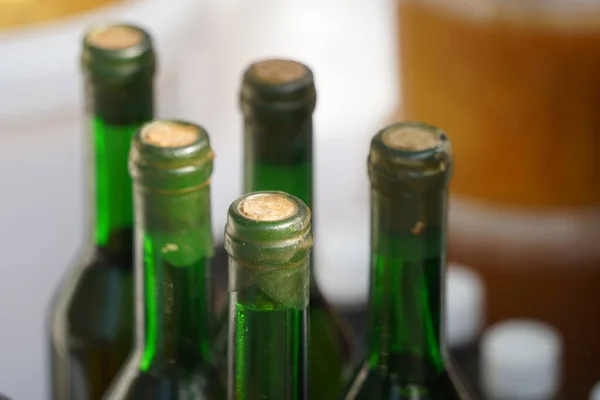 Several glass bottles with a stopper stand behind each other.