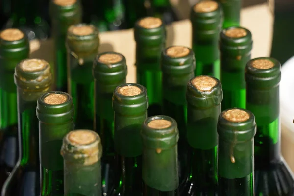 Several glass bottles with a stopper stand behind each other.