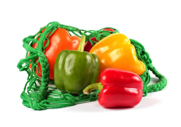 Pimentos doces frescos em um saco de corda verde — Fotografia de Stock