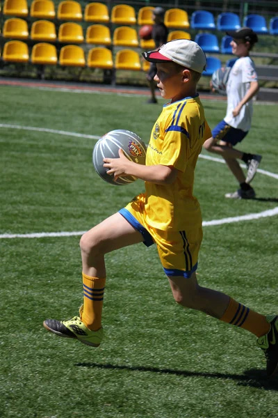 Unidentified boy runs with ball — Stock Photo, Image