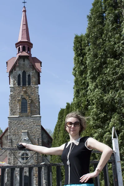 Attraktiva flicka mot bakgrund av bell tower — Stockfoto