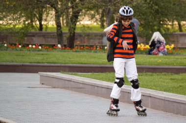 Puşkin d Bulvarı boyunca silindirler üzerinde bilinmeyen çocuk taşır