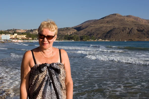 Mujer de mediana edad en gafas de sol y sarongs — Foto de Stock