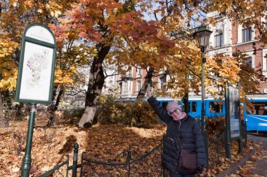 Krakow 'daki bir sonbahar parkında olgun bir kadın. Kasım 'ın başı