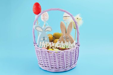 Yaratıcı Paskalya yumurtaları, mavi arka planda yuvadaki tüyler. Minimum konsept. Metin için yerin bir kopyasını içeren kart.