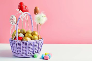 Sepet pembe arka planda paskalya yumurtası. Minimum konsept. Metin için kopyalama alanı olan kart. Paskalya dekorasyonu pilici, tavşan