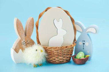 Yaratıcı Paskalya yumurtaları, mavi arka planda yuvadaki tüyler. Minimum konsept. Metin için yerin bir kopyasını içeren kart.