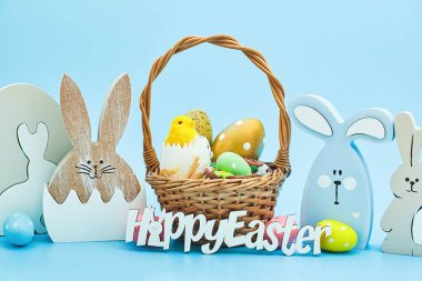 Yuvada beyaz yumurta ve mavi arka planda sarı civciv. Metin için bir paskalya kartı ve yerin bir kopyası..