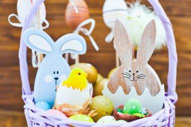 Tahta sepet içinde paskalya yumurtaları. Ahşap arka planda sarı hatunlar. Minimum konsept. Metin için bir paskalya kartı ve yerin bir kopyası..