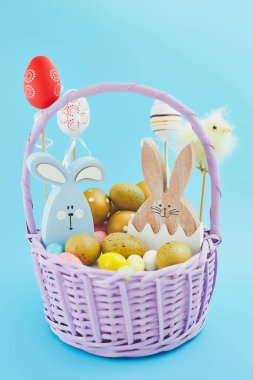 Yaratıcı Paskalya yumurtaları, mavi arka planda yuvadaki tüyler. Minimum konsept. Metin için yerin bir kopyasını içeren kart.