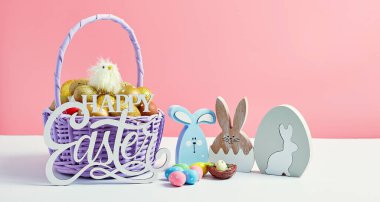 Sepet pembe arka planda paskalya yumurtası. Minimum konsept. Metin için kopyalama alanı olan kart. Paskalya dekorasyonu pilici, tavşan