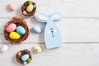 Yuvadaki zarif paskalya yumurtaları pembe arka planda ve uzayda. Minimum konsept. Metin için kopyalama alanı olan kart.