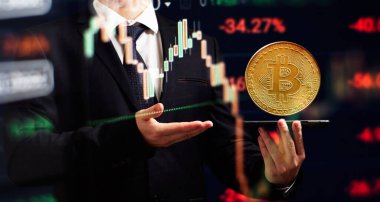 Bitcoin ticaret grafikli akıllı telefon. Elinde altın bir Bitcoin nakit para tutuyor. Kripto para değişimi ticareti..