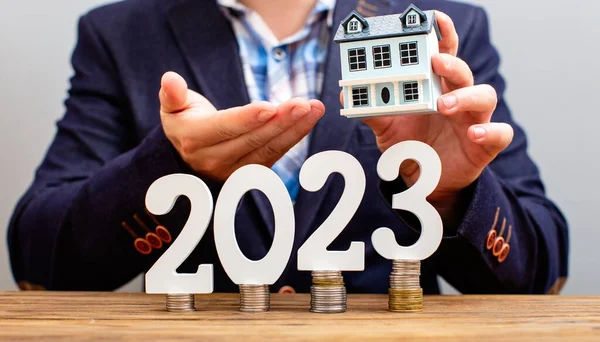 analyzes real estate profitability with augmented reality digital graphics, positive performance in 2023, businessman calculates financial data for long term investment.