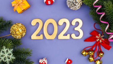 Mutlu yıllar 2023. Altın toplar, yıldızlar, pullar ve güzel bir bokeh ile 2023 sayısından bir sembol. Kutlama konsepti.