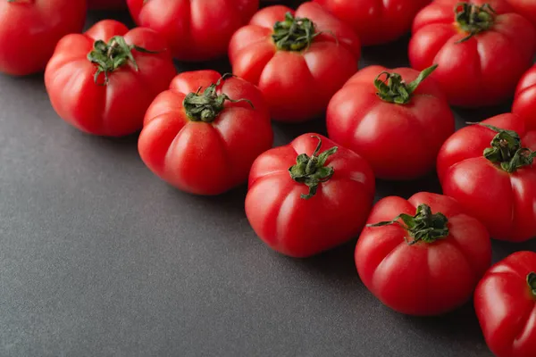 Tomates rojos frescos sobre fondo gris — Foto de Stock