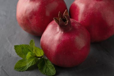 Gri arkaplanda lezzetli nar meyvesi.