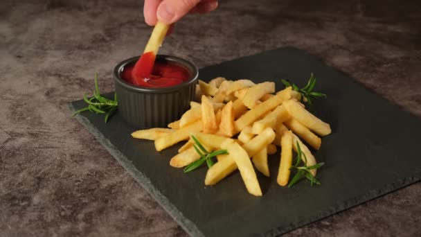 Mano tomando papas fritas y sumergiéndolas en ketchup — Vídeo de stock