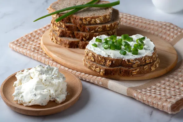 Žitný chléb na talíři se tvarohem a zelenou cibulí. Zdravotní potraviny — Stock fotografie