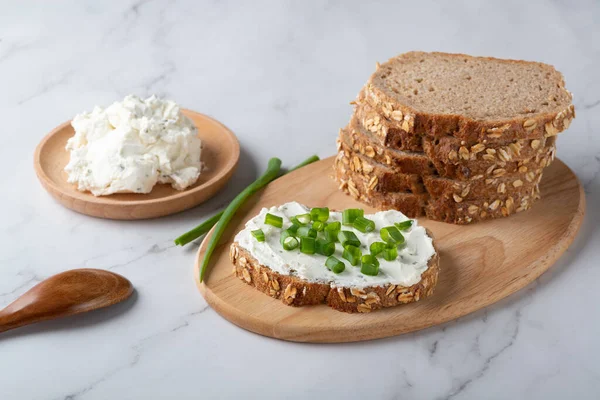 Žitný chléb na talíři se tvarohem a zelenou cibulí. Zdravotní potraviny — Stock fotografie