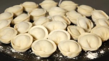 Tahta üzerinde etli börekler dönüyor, kapanıyor.