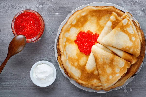 Stos rosyjskich cienkich naleśników blini z czerwonym kawiorem i świeżą śmietaną — Zdjęcie stockowe