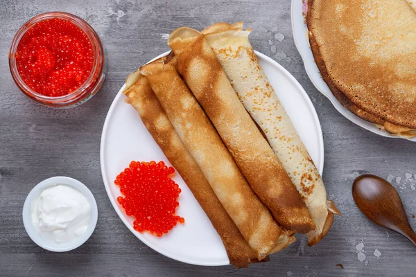 Hromada ruských tenkých palačinek blini s červeným kaviárem a čerstvou zakysanou smetanou — Stock fotografie