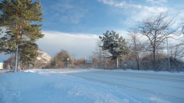 Movement of the cars in the winter. A driving on snow road, to a clear sunny day
